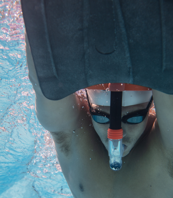 man swimming in the pool with titanium goggles, snorkel, kickboard