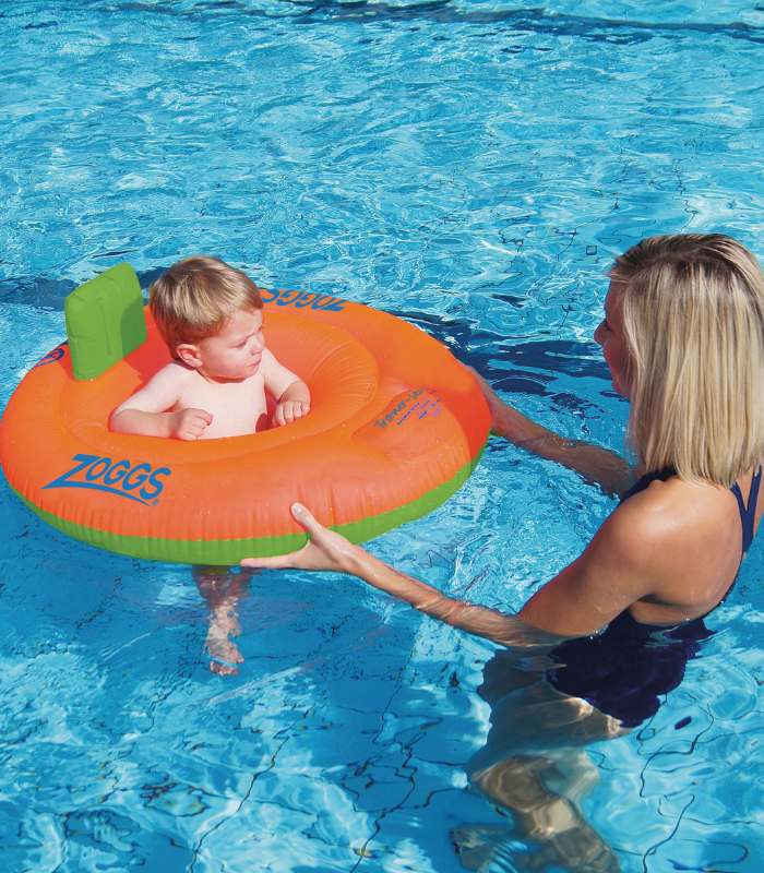 baby in a training seat in the pool with mum