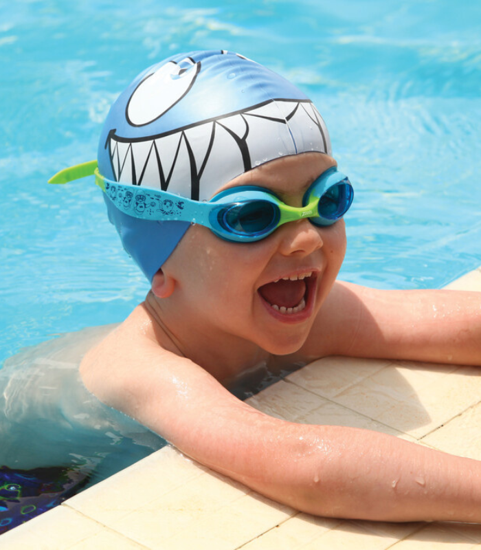 child boy smiling in little twist goggles and shark cap