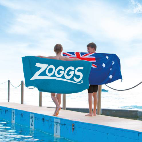 Man wearing a Zoggs cap and putting on a goggle