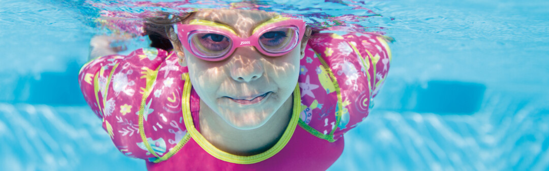 girl swimming underwater wearing a water wings vest and little sonic air